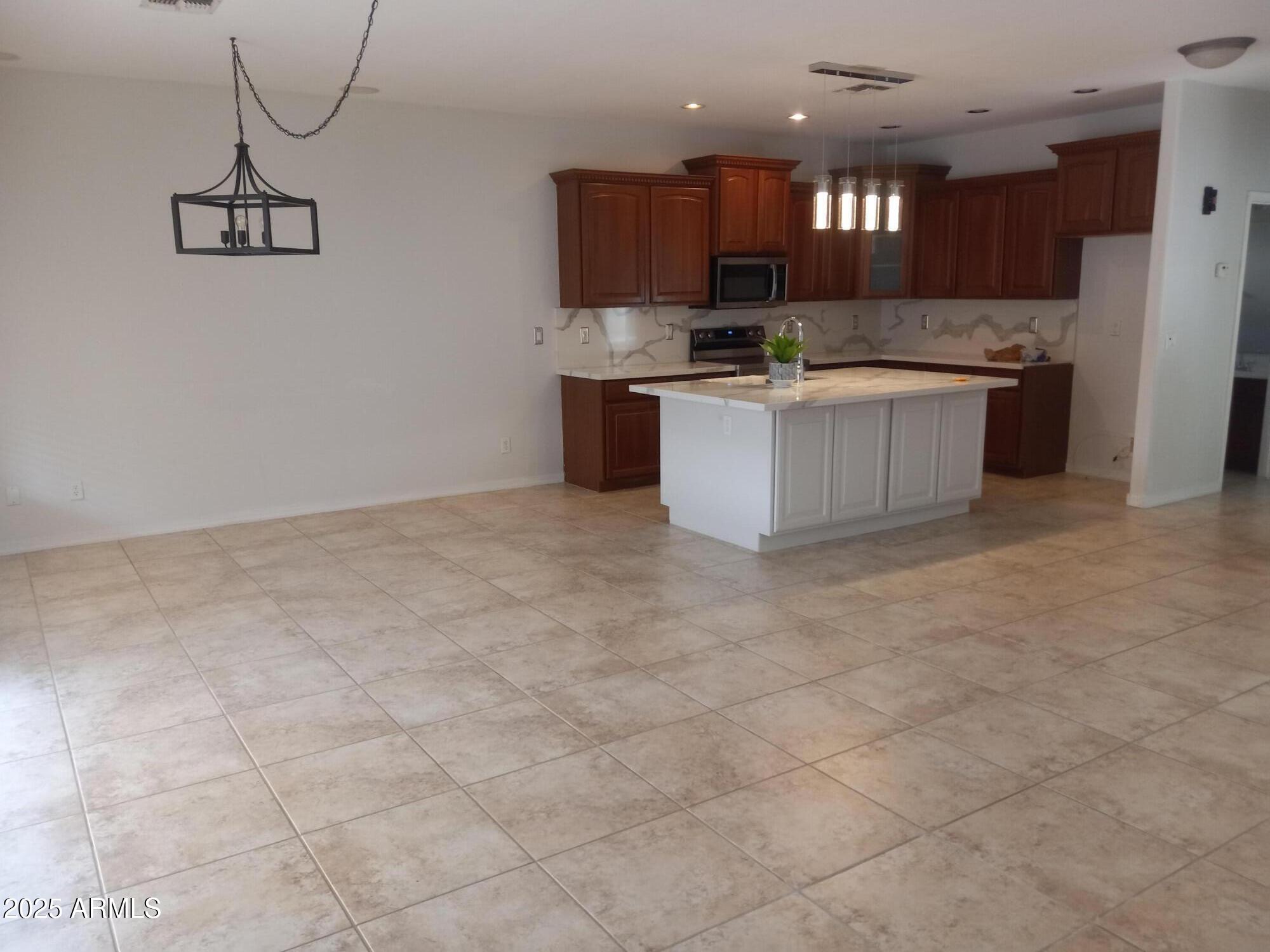 3947 West Roundabout Circle Chandler, AZ 85226 - Photo 11 of 32 a kitchen with stainless steel appliances a sink a stove a refrigerator and cabinets