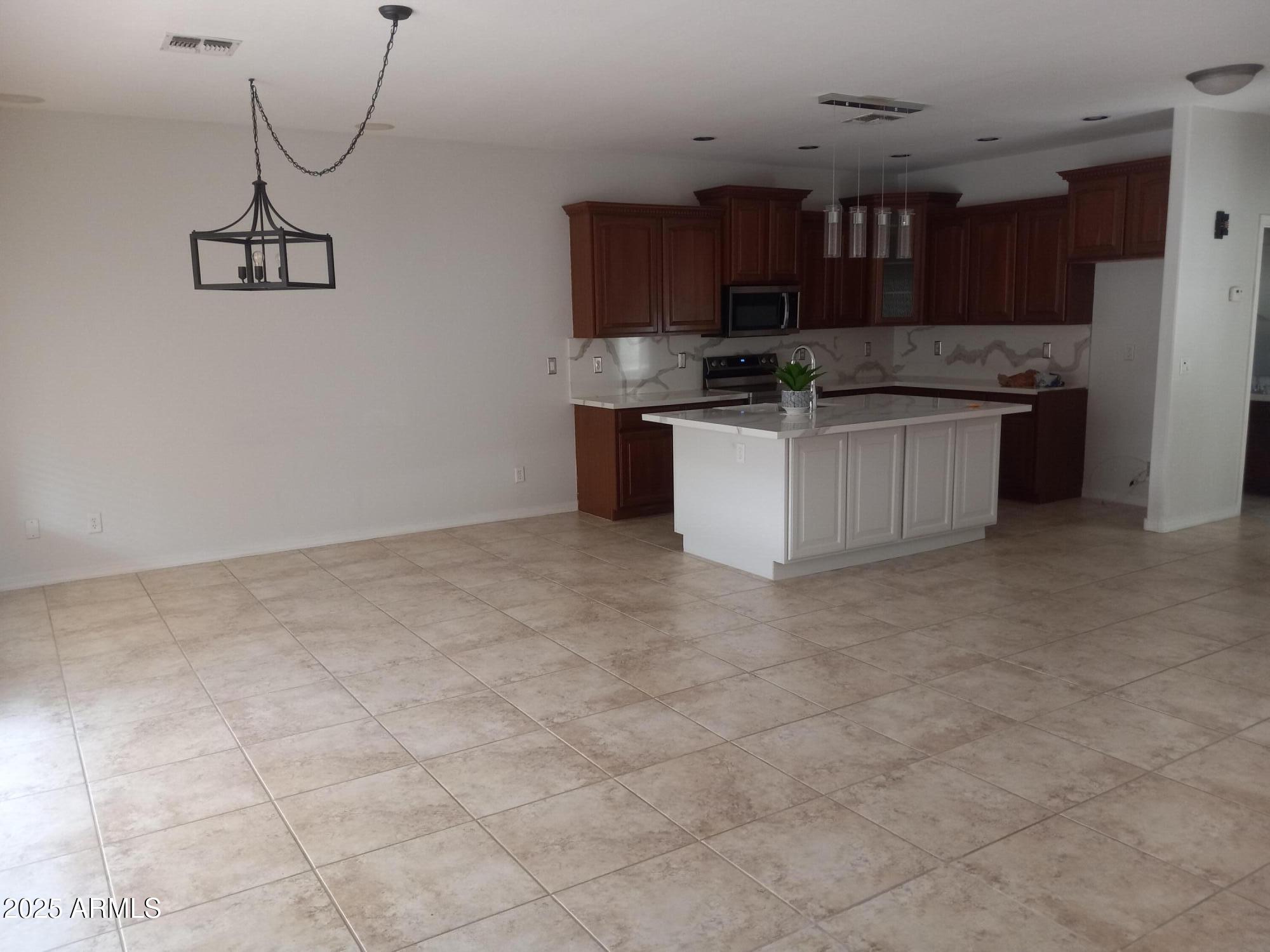 3947 West Roundabout Circle Chandler, AZ 85226 - Photo 10 of 32 a kitchen with stainless steel appliances granite countertop a stove a sink and a refrigerator