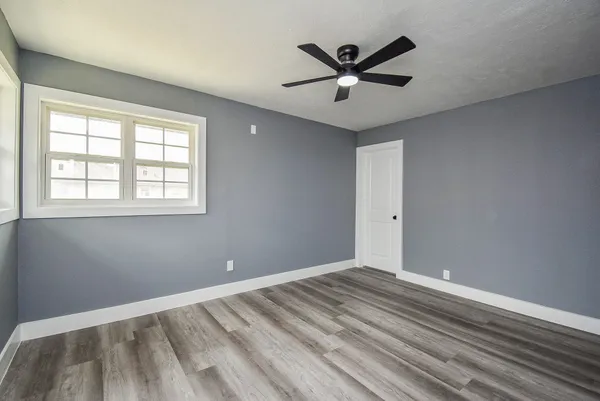 a view of a big room with wooden floor and windows