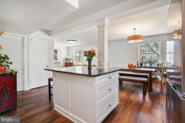 a kitchen with white cabinets and sink