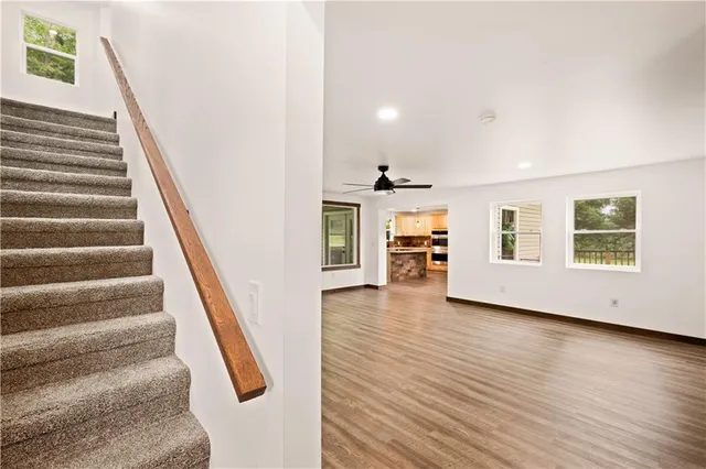a view of an entryway with wooden floor and a kitchen