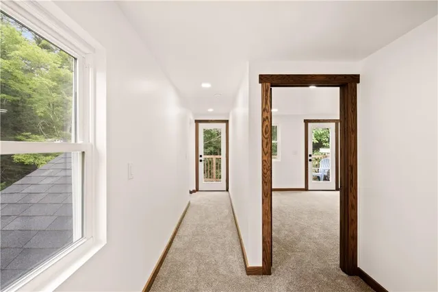 a view of a hallway with wooden floor and a living room