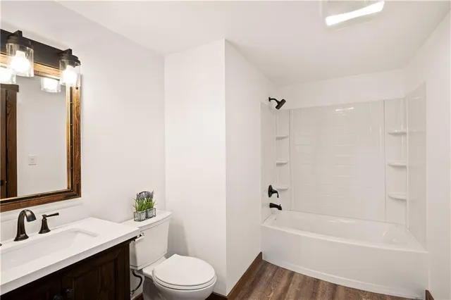 a bathroom with a bathtub shower sink vanity mirror and toilet