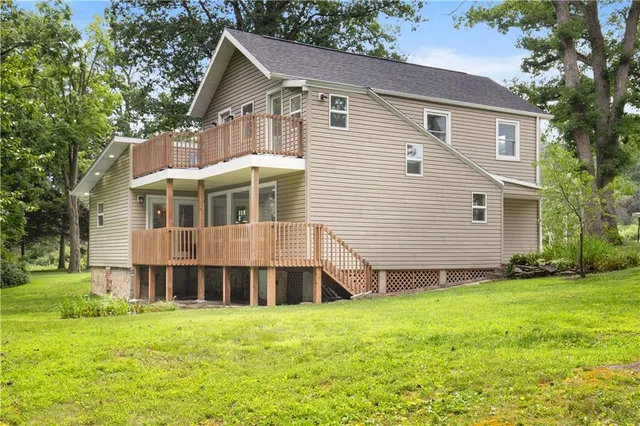 a front view of a house with a yard and trees