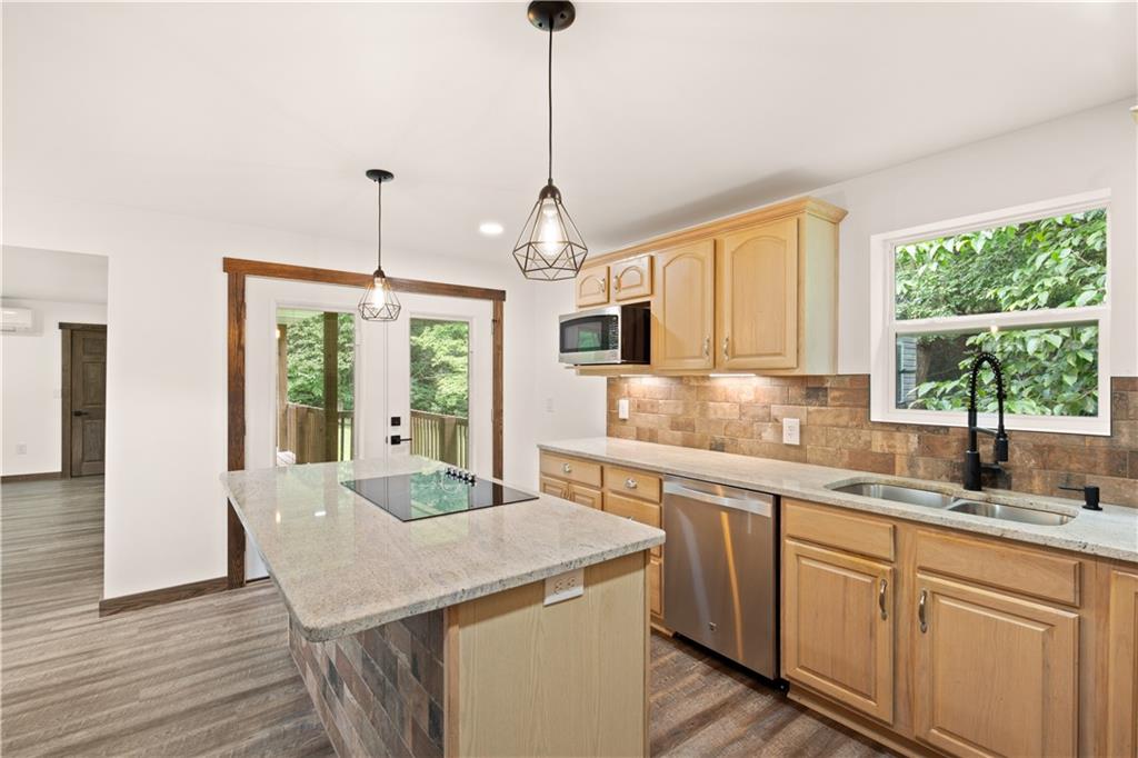 480 Freeman Falls Road Acme, PA 15610 - Photo 10 of 43 a kitchen with a stove a sink dishwasher a kitchen island with wooden cabinets and wooden floor