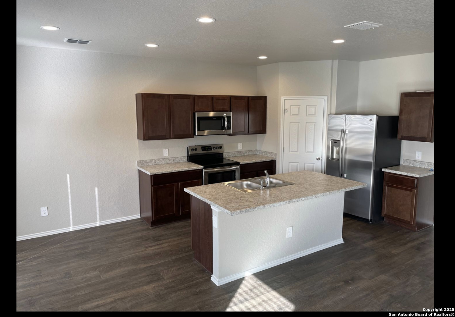13121 Candace Way St. Hedwig, TX 78152 - Photo 2 of 13 a kitchen with stainless steel appliances a sink a stove a microwave a refrigerator a counter top and cabinets
