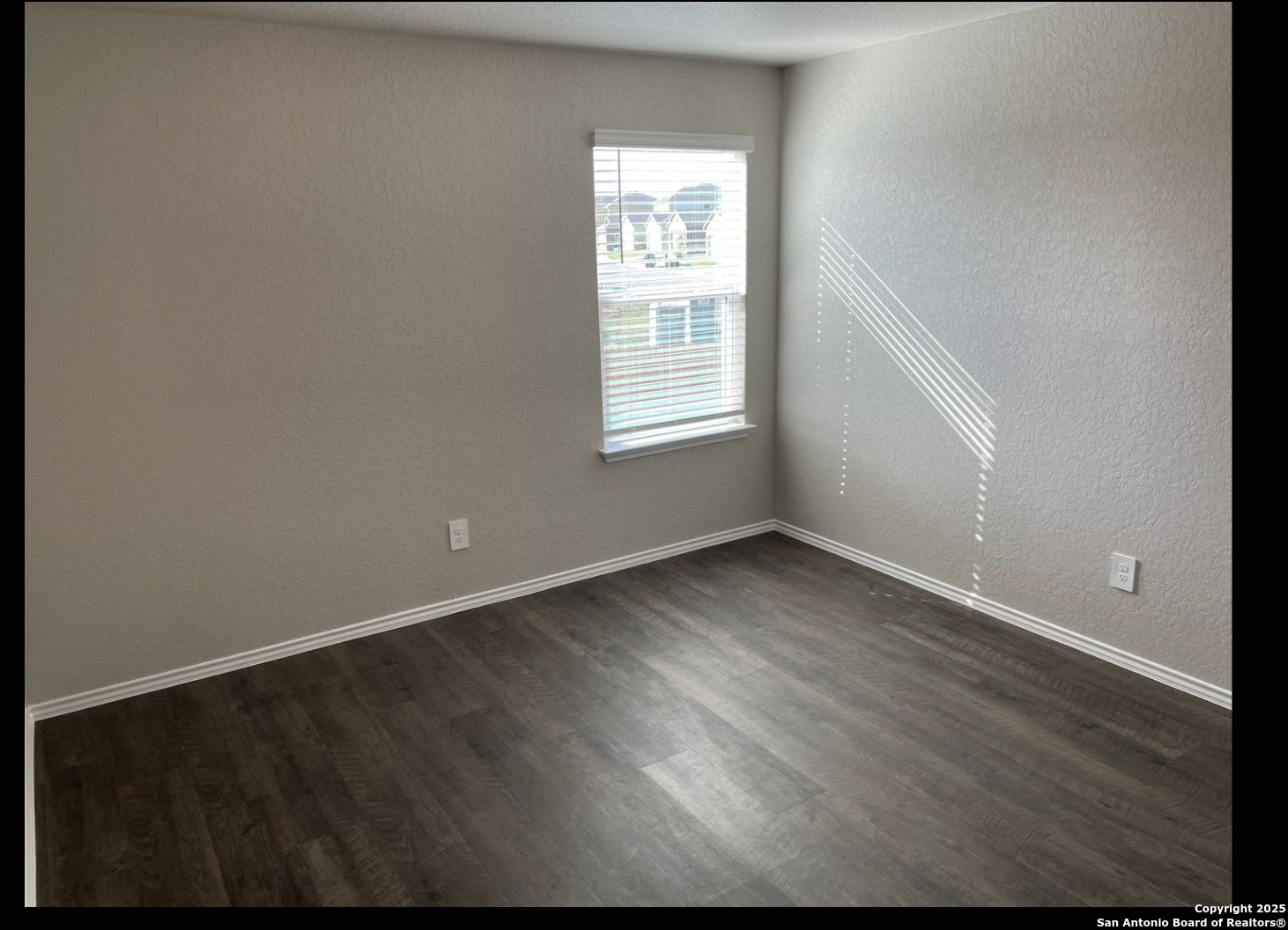 13121 Candace Way St. Hedwig, TX 78152 - Photo 4 of 13 an empty room with wooden floor and windows