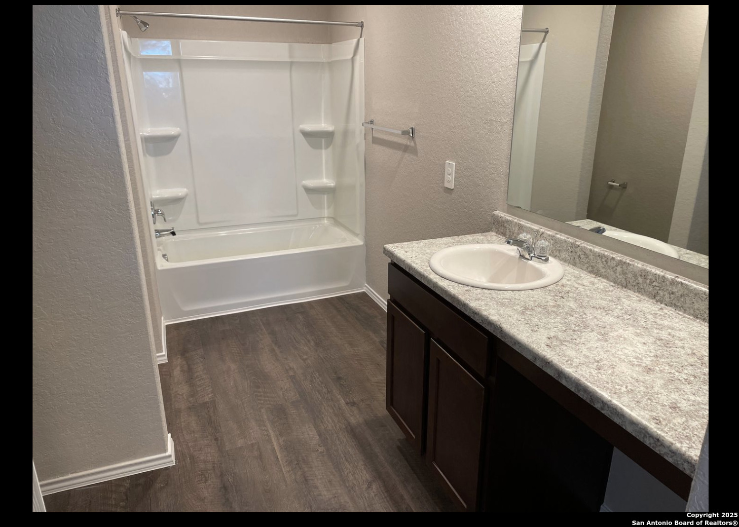 13121 Candace Way St. Hedwig, TX 78152 - Photo 7 of 13 a bathroom with a granite countertop sink a mirror and a bathtub