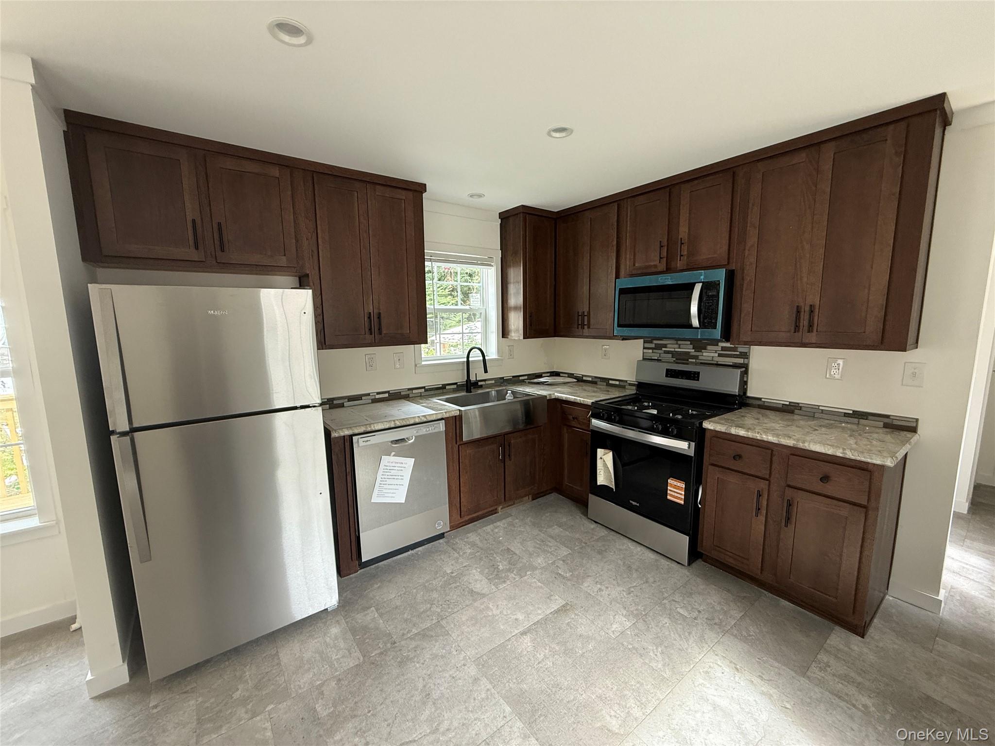 128 Forest Park Wallkill, NY 12589 - Photo 4 of 19 a kitchen with granite countertop a refrigerator stove and microwave