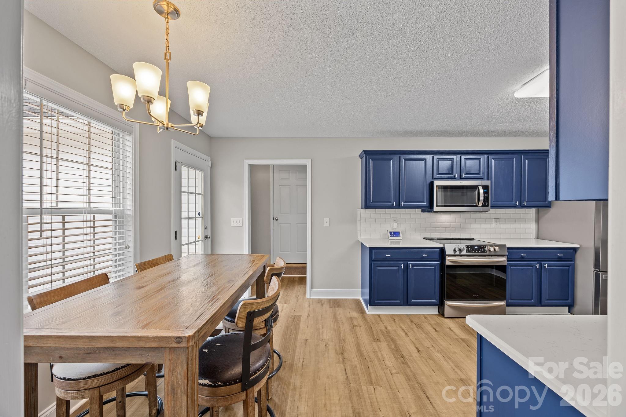 1749 Sells Road Salisbury, NC 28144 - Photo 12 of 47 a kitchen with stainless steel appliances granite countertop a kitchen island hardwood floor sink stove dining table and chairs