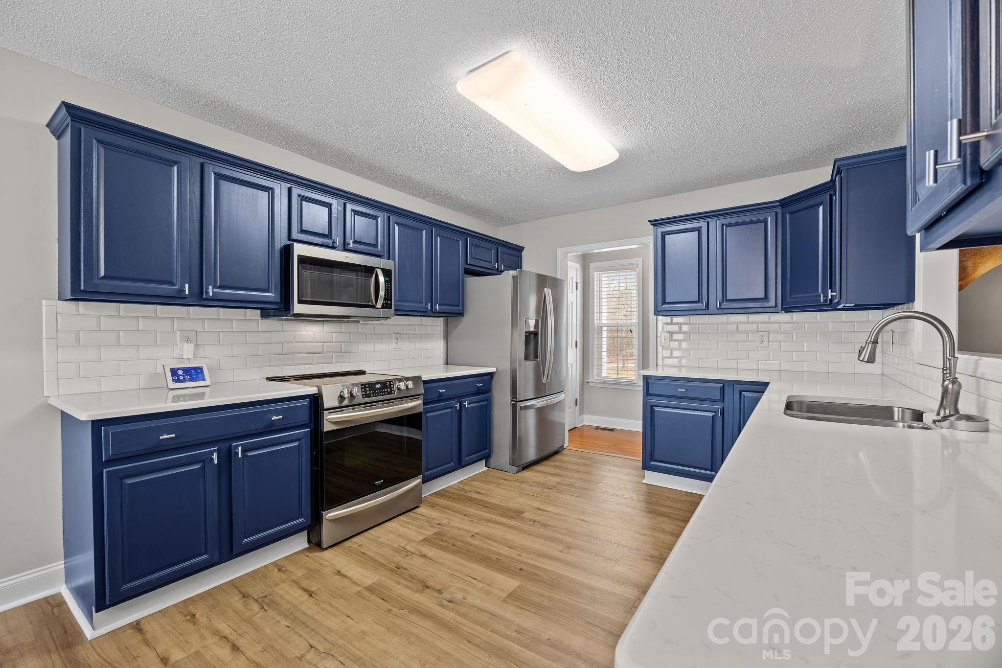 1749 Sells Road Salisbury, NC 28144 - Photo 16 of 47 a kitchen with stainless steel appliances granite countertop a sink stove microwave and refrigerator