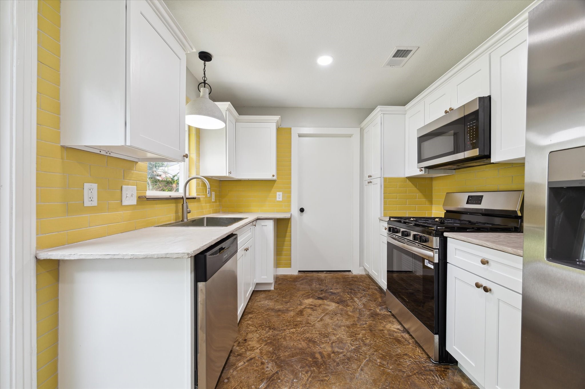522 Barkley Street Houston, TX 77022 - Photo 4 of 18 Remodeled kitchen with fresh cabinetry, poured concrete counters, new stainless appliances. The gas range is an added bonus! Door at the end leads to the laundry room.