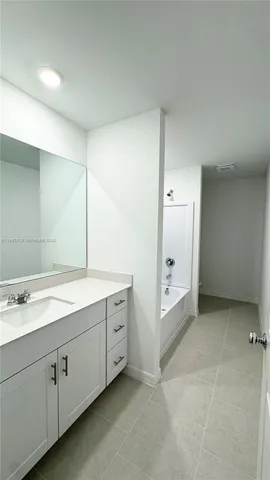 a spacious bathroom with a double vanity sink a mirror and a bathtub