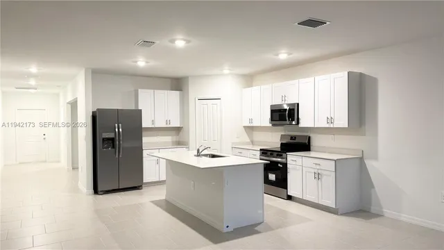 a kitchen with stainless steel appliances a refrigerator stove microwave and sink