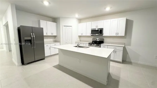 a kitchen with stainless steel appliances a refrigerator sink and microwave