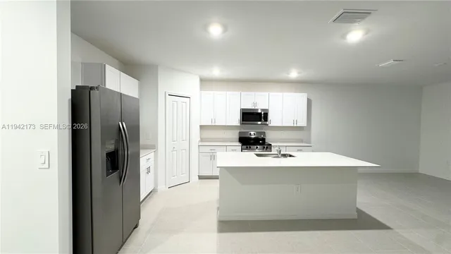a kitchen with stainless steel appliances a refrigerator sink and microwave