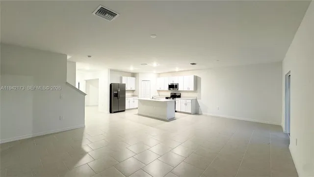 a view of a kitchen with furniture and an empty room