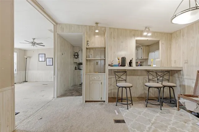 a kitchen with refrigerator and chairs