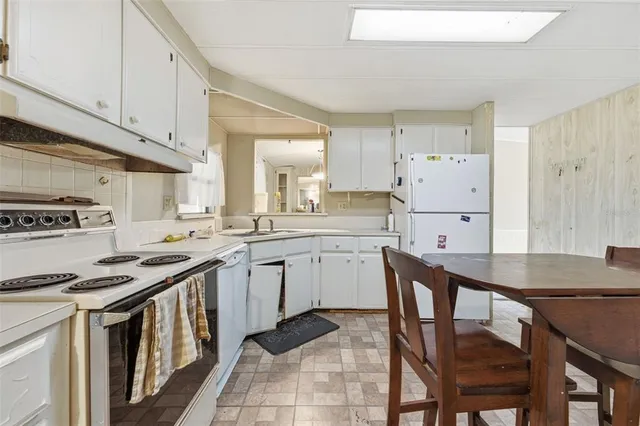 a kitchen with a stove a sink dishwasher and a refrigerator