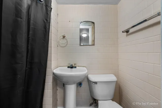a bathroom with a toilet a sink and mirror
