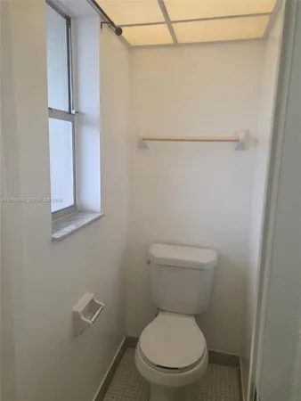 a white toilet sitting next to a shower