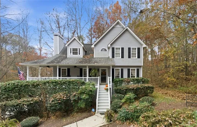 a front view of a house with a yard and trees