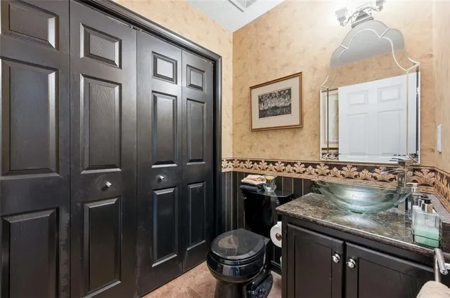 a bathroom with a granite countertop sink and a toilet