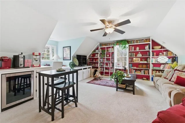 a living room with furniture a rug and a bookshelf