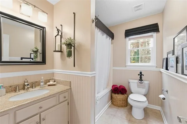 a bathroom with a sink vanity mirror and toilet
