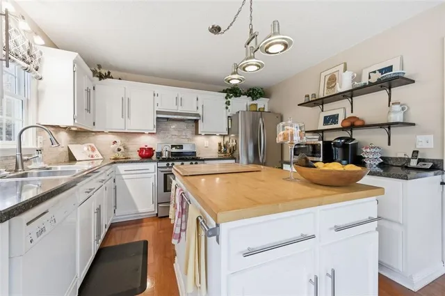 a kitchen with a stove a sink and a refrigerator