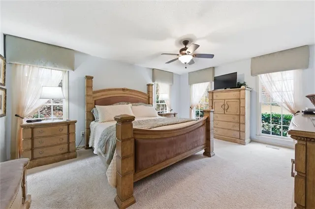 a spacious bedroom with a bed and a chandelier