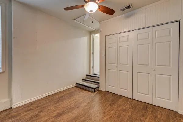 a view of wooden floor and chandelier fan in an empty room