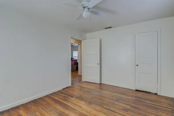 a view of an empty room with wooden floor