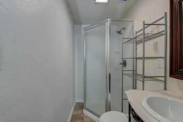 a bathroom with a sink a toilet and shower
