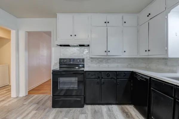a kitchen with granite countertop white cabinets and stainless steel appliances
