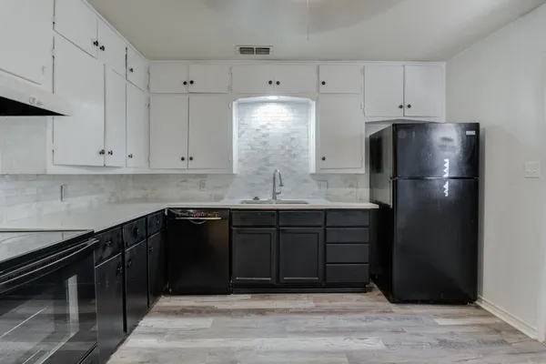 a kitchen with stainless steel appliances granite countertop a refrigerator and a stove