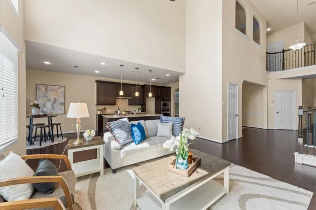 a living room with furniture and a dining table with wooden floor