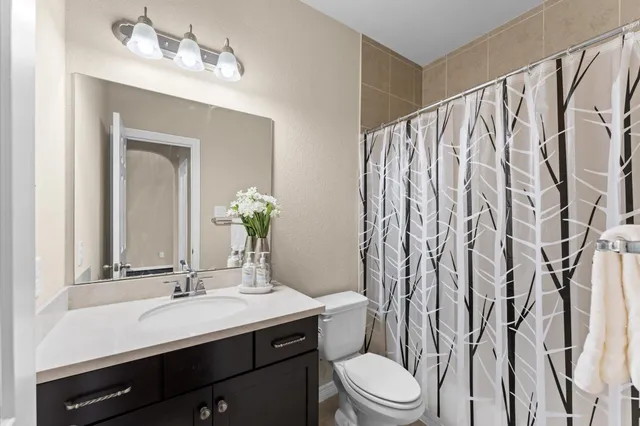 a bathroom with a sink vanity mirror and toilet