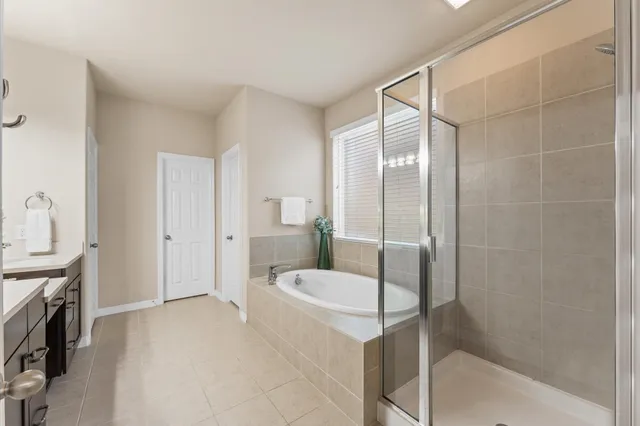 a bathroom with a tub a sink and a mirror