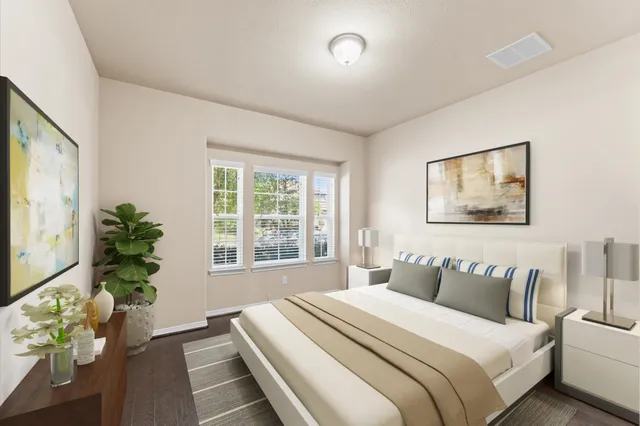 a bedroom with a large bed and a potted plant