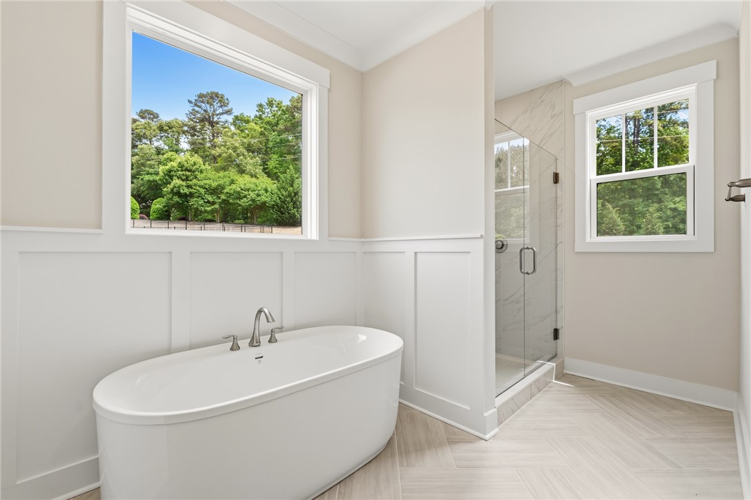 203 Timothy Court Anderson, SC 29621 - Photo 36 of 40 A spacious bathroom sanctuary features a freestanding oval tub and a walk-in shower with clear glass enclosure.