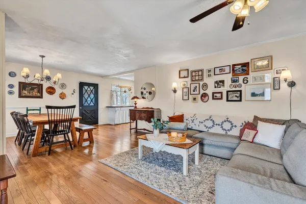 a view of a a dining room with furniture window and wooden floor