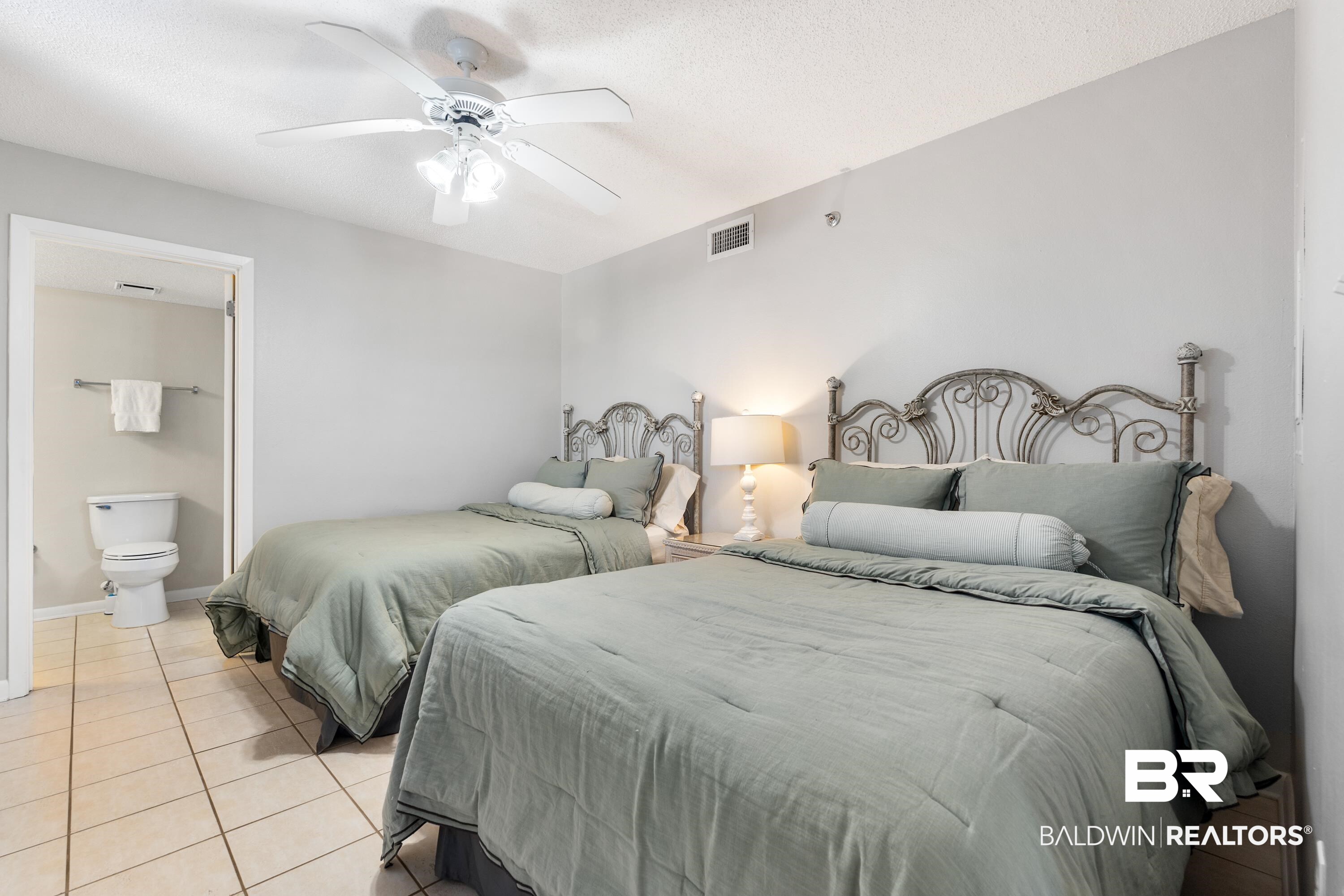26802 Perdido Beach Boulevard, Unit 406 Orange Beach, AL 36561 - Photo 15 of 37 Bedroom with ceiling fan, light tile patterned floors, and a textured ceiling