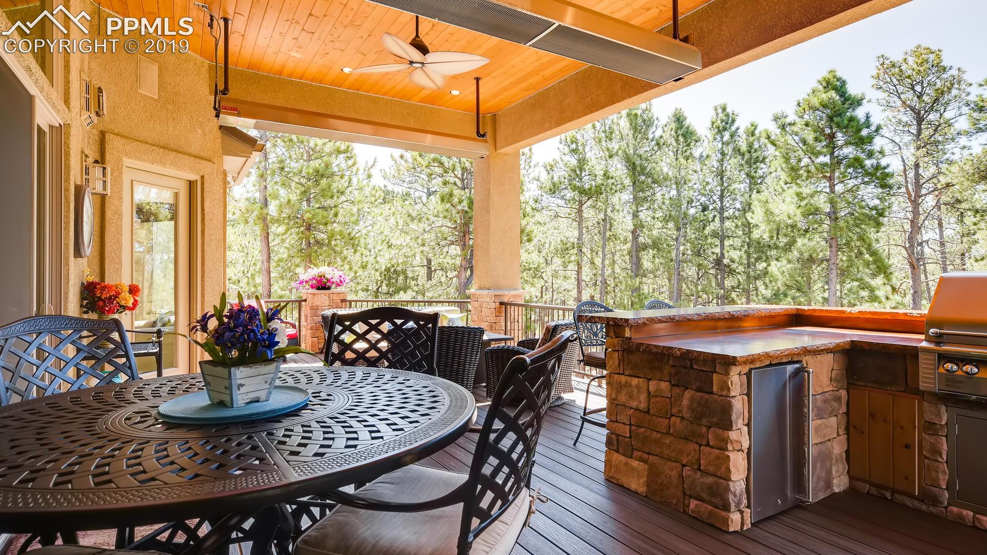 4061 High Forest Road Colorado Springs, CO 80908 - Photo 12 of 40 Covered outdoor living space w/Calcana ceiling heaters, composite decking, wood ceiling, ceiling fan...