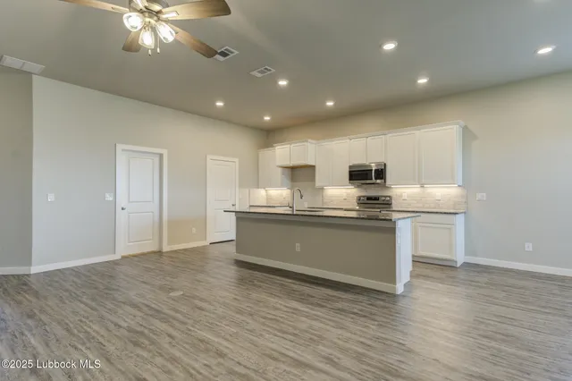 a kitchen with stainless steel appliances granite countertop a sink a stove and a microwave