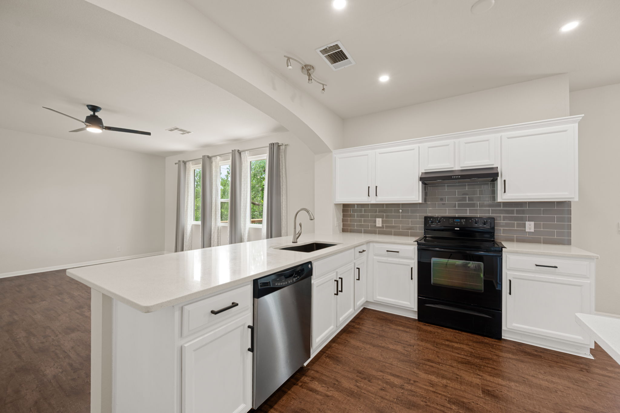 8902 Magna Carta Loop, Unit 122 Austin, TX 78754 - Photo 10 of 39 A contemporary kitchen features bright white cabinetry and an inviting island, perfect for culinary endeavors.
