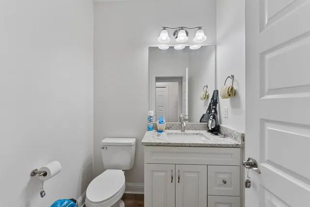 a bathroom with a sink vanity mirror and toilet