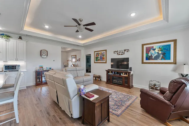a living room with furniture and a flat screen tv with wooden floor