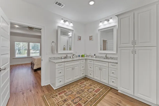 a spacious bathroom with a granite countertop sink a mirror and a toilet