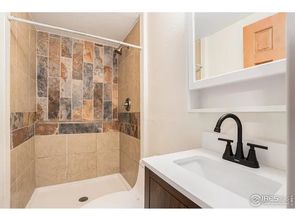 a bathroom with a shower sink and mirror